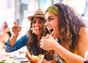 Friends smiling while enjoying meal in restaurant