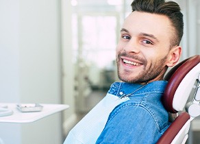 Patient smiling while sitting in dentist treatment chair