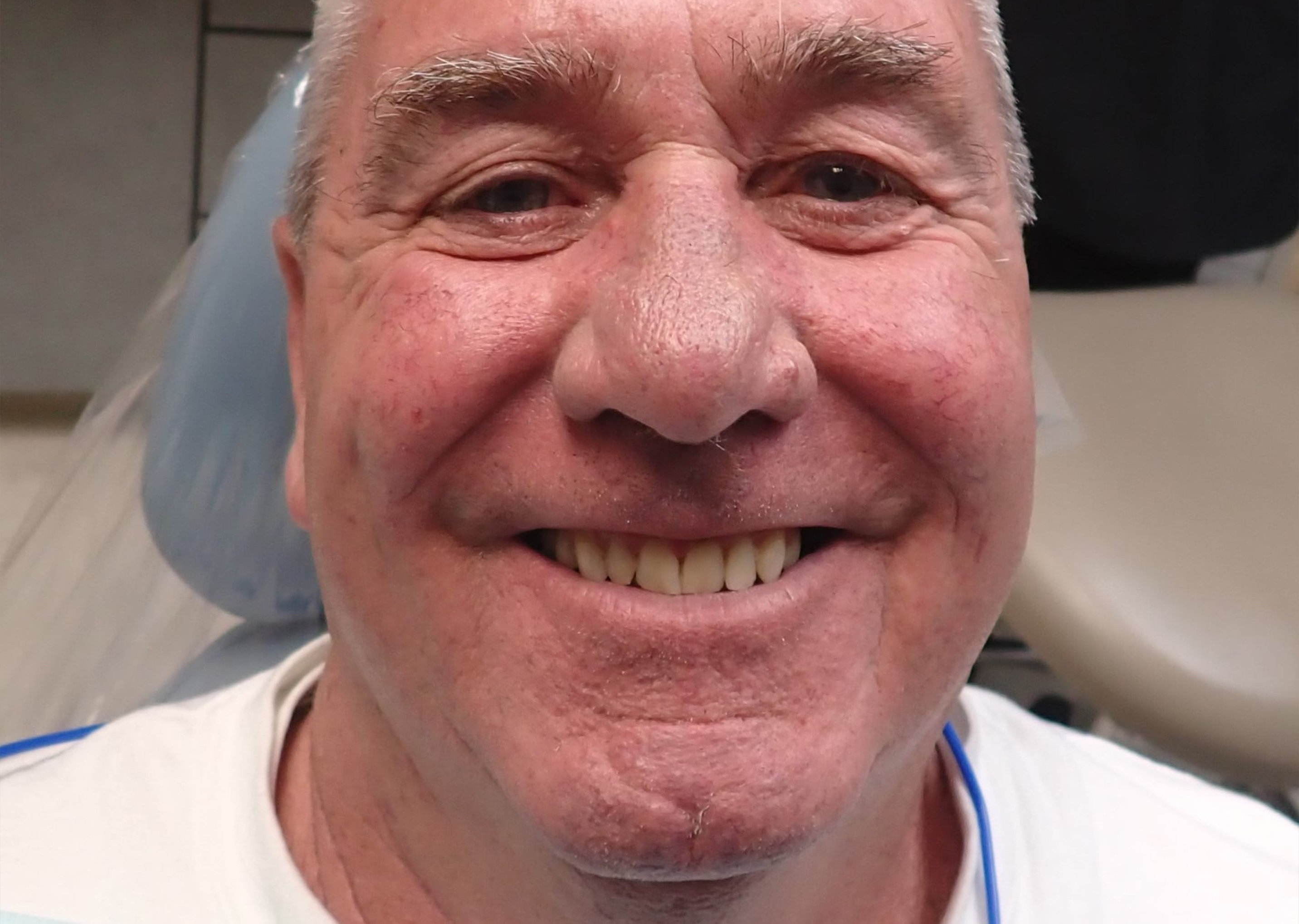 Senior man sitting in dental chair smiling