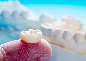 Dental crown resting on a finger