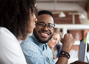 Man smiling at person sitting next to him