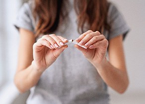 Woman breaking a cigarette in half