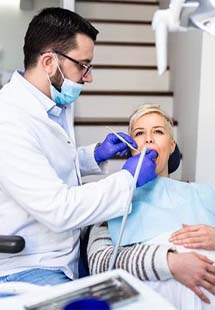 Dentist treating senior woman in dental chair