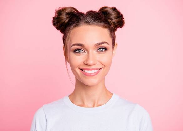 woman smiling against pink background 